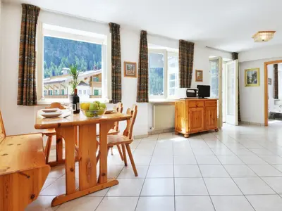 a kitchen and dining room with a table and windows at Apartment Villa Placidia Apt 23 by Interhome in Campitello di Fassa