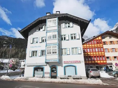 a tall white building with a black roof at Apartment Villa Placidia Apt 23 by Interhome in Campitello di Fassa