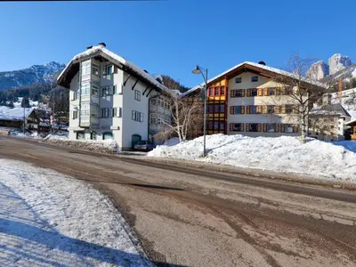 an empty street with a building and snow at Apartment Villa Placidia Apt 23 by Interhome in Campitello di Fassa