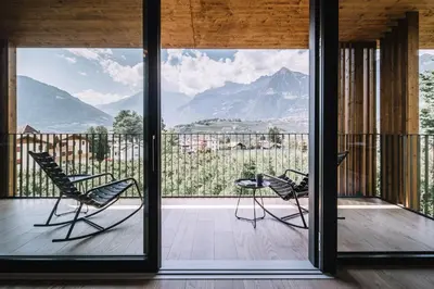 a house with a view of mountains from a balcony at Das Hallinger am Waidmannhof in Merano