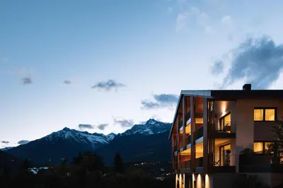 a building with the mountains in the background at Das Hallinger am Waidmannhof in Merano