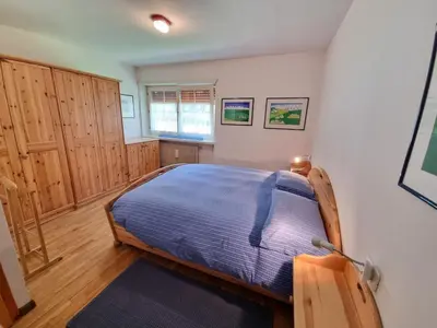 a bedroom with a bed in a room with wooden cabinets at NEGRITELLA in Alba di Canazei