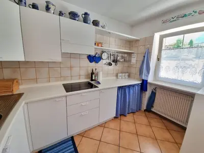 a kitchen with white cabinets and a window and a sink at NEGRITELLA in Alba di Canazei