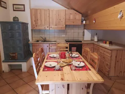 a kitchen with a wooden table and chairs in it at NEGRITELLA in Alba di Canazei