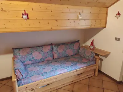 a couch sitting in the corner of a room at NEGRITELLA in Alba di Canazei