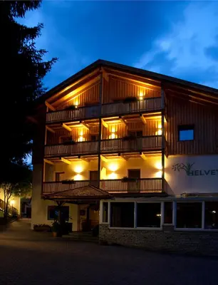 a building with lights on the side of it at Garni Appartments Helvetia in Villabassa