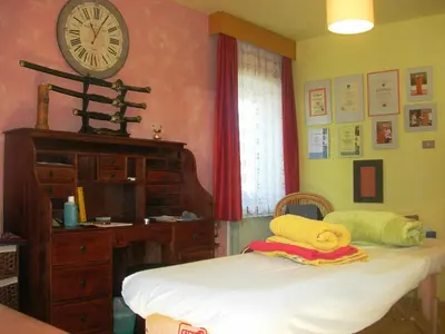 a bedroom with a bed and a clock on the wall at Garni Appartments Helvetia in Villabassa