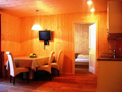 a dining room with a table and chairs and a television at Appartments Helvetia in Villabassa