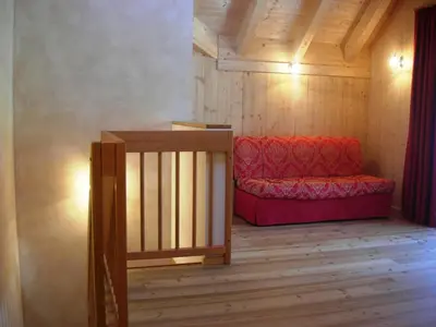 a room with a red couch in the corner of a room at Appartments Helvetia in Villabassa