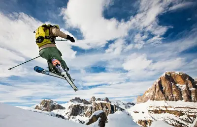a man flying through the air while riding skis at Hotel Corona in Cortina dʼAmpezzo