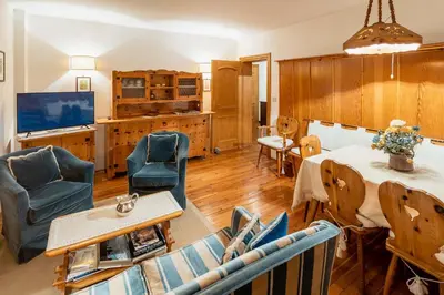 a living room with blue chairs and a table at Villa Radiosa - Stayincortina in Cortina dʼAmpezzo