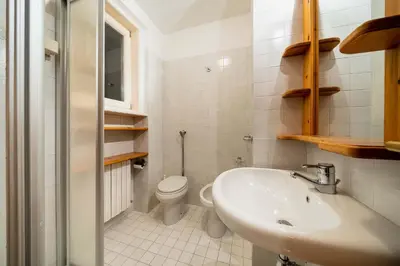 a white bathroom with a sink and a toilet at Villa Radiosa - Stayincortina in Cortina dʼAmpezzo