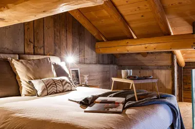 a bedroom with a bed with a wooden ceiling at Luxury Wellness Lusiaski in Bellamonte