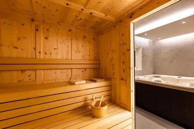 a sauna with a tub and a sink at Luxury Wellness Lusiaski in Bellamonte