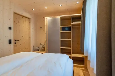 a bedroom with a white bed and a closet at Unterhuberhof in Albes