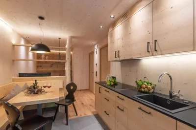 a kitchen with wooden cabinets and a sink and a table at Unterhuberhof in Albes