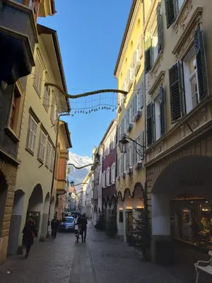 a street with buildings and people walking down a street at Portico 32 - Merano centro in Merano
