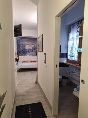 a hallway leading to a bedroom with a bed at Portico 32 - Merano centro in Merano