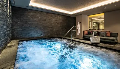 a hot tub in the middle of a room at Ciampedie Luxury Alpine Spa Hotel in Vigo di Fassa