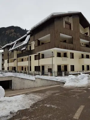 a building with snow on the ground in front of it at Des Alpes 1 in Canazei
