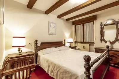 a bedroom with a large bed and a mirror at Des Alpes 1 in Canazei