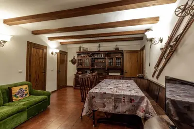 a dining room with a table and a green couch at Des Alpes 1 in Canazei