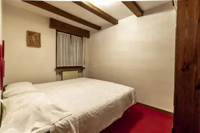 a bedroom with a white bed in a room at Des Alpes 1 in Canazei