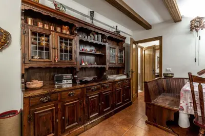 a large kitchen with wooden cabinets and a counter at Des Alpes 1 in Canazei