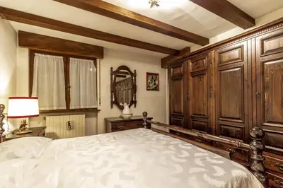 a bedroom with a large bed and wooden cabinets at Des Alpes 1 in Canazei