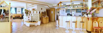 a room with a kitchen with a counter and a room with at Gasthof St. Ulrich in Meltina