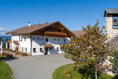 a large white building with a brown roof at Gasthof St. Ulrich in Meltina