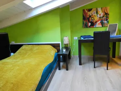 a bedroom with a bed and a desk with a laptop at White Tower of Love in Bressanone