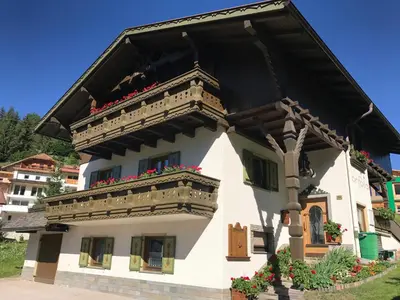 a building with a balcony and flowers on it at Ciasa Confolia in San Vigilio Di Marebbe