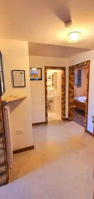 a room with a hallway with a bedroom and a bed at Ciasa Confolia in San Vigilio Di Marebbe