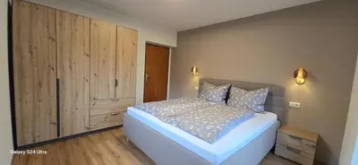 a bedroom with a bed and a large wooden cabinet at Ciasa Confolia in San Vigilio Di Marebbe
