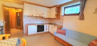 a small kitchen with white cabinets and a window at Ciasa Confolia in San Vigilio Di Marebbe