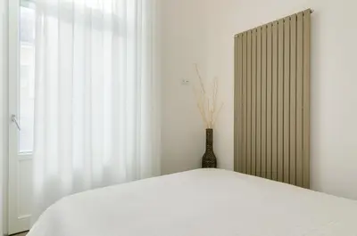 a bedroom with a bed and a vase next to a window at Vinci16 in Bolzano