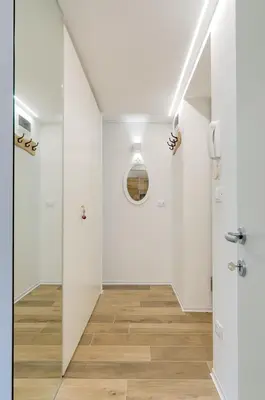 a hallway with white walls and wood floors at Vinci16 in Bolzano