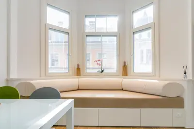 a living room with a couch and three windows at Vinci16 in Bolzano
