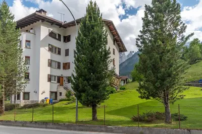 a large white building with trees in front of it at Suite Marangon in Falcade