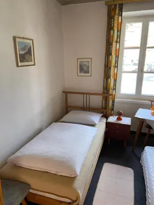 two beds in a room with a window at Gasthof Albergo Ressmair in Merano