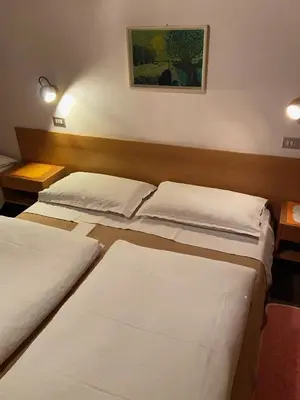 a room with three beds in a room at Gasthof Albergo Ressmair in Merano