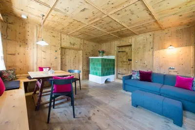 a living room with a blue couch and a table at Hofbauer in Brunico