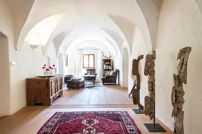 a living room with arched ceilings and a rug at Hofbauer in Brunico