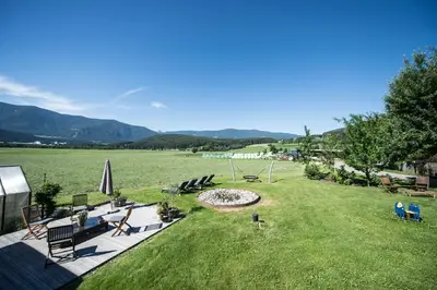 a lawn with chairs and a fire pit in a field at Hofbauer in Brunico