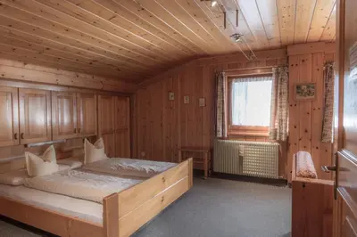 a bedroom with a bed in a wooden room at Apartments La Vara in Corvara in Badia