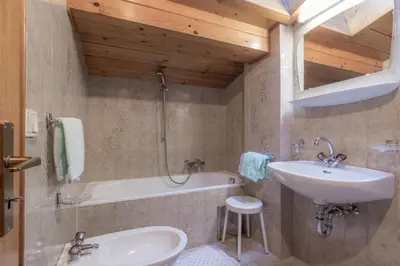a bathroom with a sink and a bath tub at Apartments La Vara in Corvara in Badia