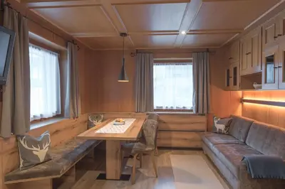 a living room with a table and a couch at Apartments La Vara in Corvara in Badia