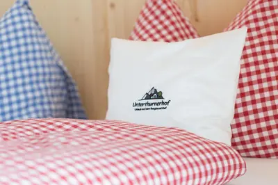 a bed with red and white pillows on it at Unterthurnerhof in Rifiano