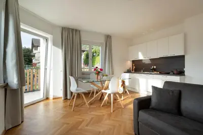 a kitchen and a living room with a table and chairs at MeranoView Apartments in Marlengo